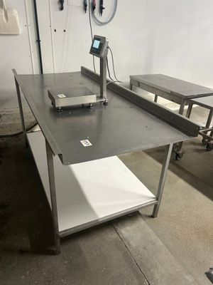 une table sur laquelle est posée une balance, dans une pièce