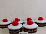 four red pom poms sitting on top of a white table