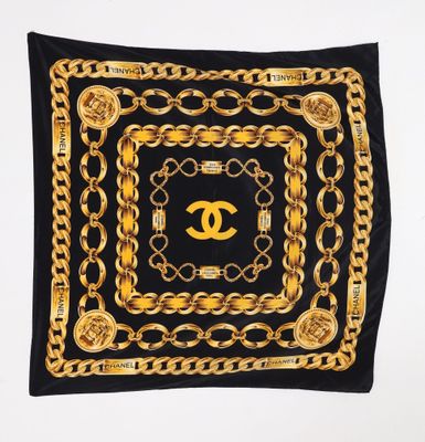 a black scarf with gold chains and a chanel logo