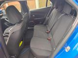 the back seats of a blue car with a yellow sticker on it