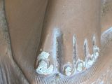 a close up of a person ' s foot in the mud
