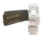 a gucci watch and a card on a white surface