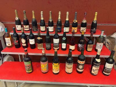 plusieurs bouteilles de vin sur une étagère rouge