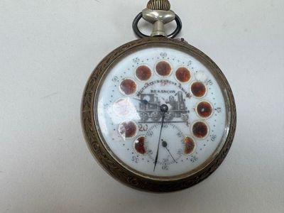 une montre de poche sur laquelle figure une horloge, posée sur une table