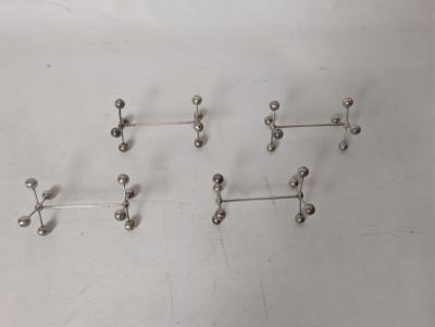 five pairs of silver balls on a white surface