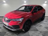 une voiture rouge garée dans un garage au sol en damier