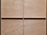 a close up of a wooden cabinet in a room with a black wall