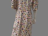 an image of a mannequin wearing a pink dress with black and yellow flowers