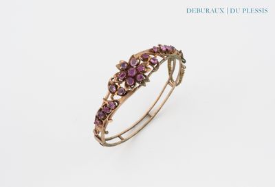 a close up of a ring with purple stones on a white background