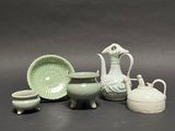 many different pieces of pottery sitting on a table
