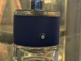 un flacon de parfum posé sur une table en verre dans la vitrine d'un magasin
