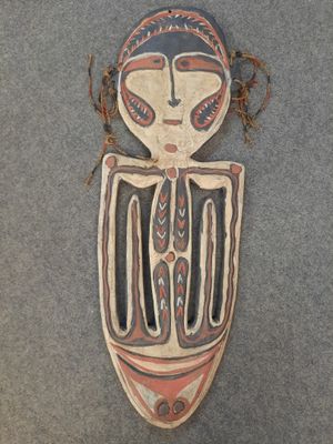 gros plan d'un masque en bois sur une surface grise