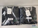 two black t - shirts are wrapped in plastic bags on a table