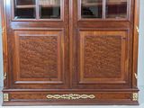 a large wooden cabinet with glass doors and a clock on top