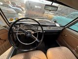 a steering wheel and dashboard of a car in a parking lot