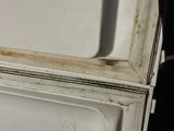 a white refrigerator with a dirty door in a kitchen