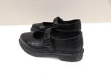pair of black children ' s shoes on a white surface