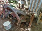 un tracteur rouillé avec un seau de peinture à côté