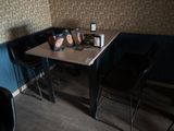 a table with two chairs and a bag of coffee on top of it