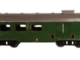 a green train car that is sitting on a white surface