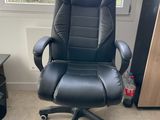 une chaise de bureau noire placée devant une fenêtre