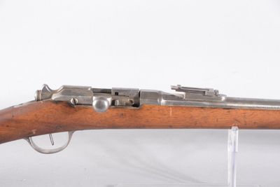 un gros plan d'un fusil exposé sur une surface blanche