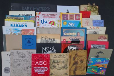 une pile de livres posée sur une table, sur fond noir