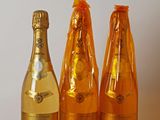 trois bouteilles de champagne posées sur une table l'une à côté de l'autre