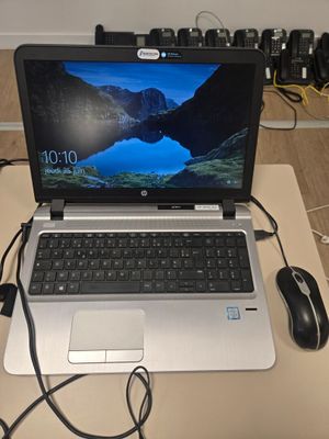 un ordinateur portable posé sur un bureau, avec une souris à côté