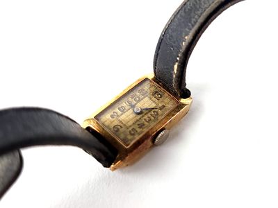 a watch that is sitting on a black leather strap