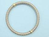 a close up of a gold bracelet on a blue surface