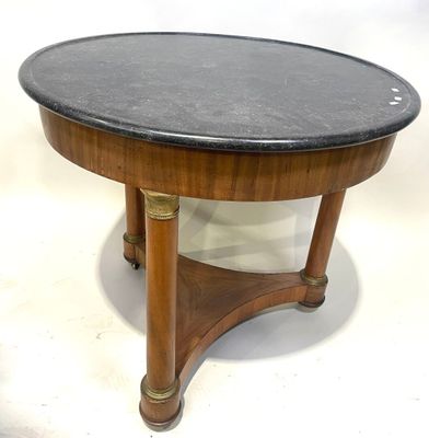 une table basse avec un plateau en marbre noir reposant sur un piètement en bois