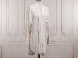 une robe blanche posée sur un pied de mannequin dans une pièce
