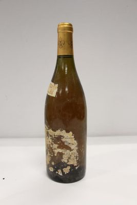 a close up of a bottle of wine on a white surface