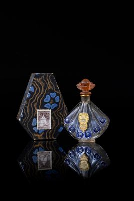 two bottles of perfume sitting next to each other on a black surface