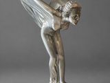 a silver statue of a woman with wings on a black base
