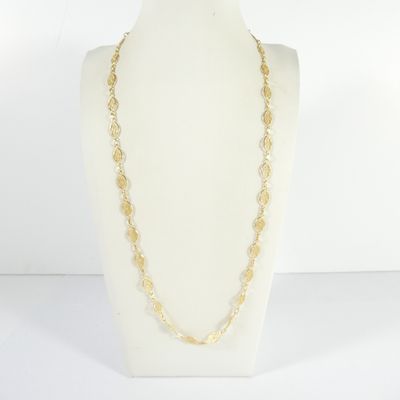 un collier à chaîne en or sur un présentoir avec un mannequin blanc