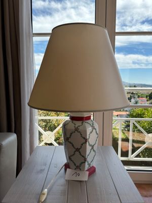 une lampe posée sur une table devant une fenêtre