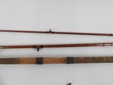 two old fishing rods and a fishing rod on a white surface