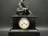 une statue de femme assise au sommet d'une horloge