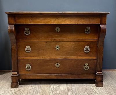 une commode ancienne dont les tiroirs sont ornés de ferrures en laiton