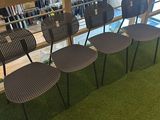 four chairs that are sitting on the grass in front of a window