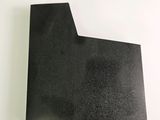 a close up of a piece of black paper on a white surface