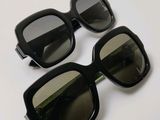 deux paires de lunettes de soleil noires posées sur une table blanche