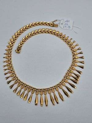 a gold necklace with spikes and spikes on it