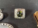 a green and white diamond ring sitting on top of a table