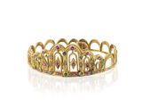 une bague en forme de couronne dorée, ornée de pierres multicolores sur fond blanc