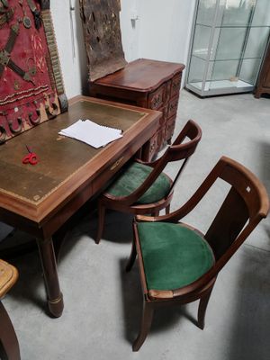 des tables et des chaises dans une pièce où un tapis est accroché au mur