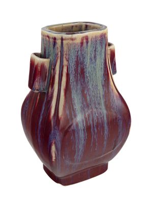un petit vase muni d'une anse sur fond blanc
