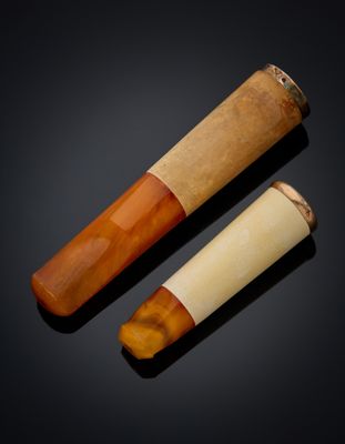 pair of carved bone and wood smoking pipes on a black background